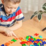 child playing word games with plastic letters