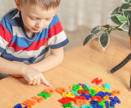 child playing word games with plastic letters