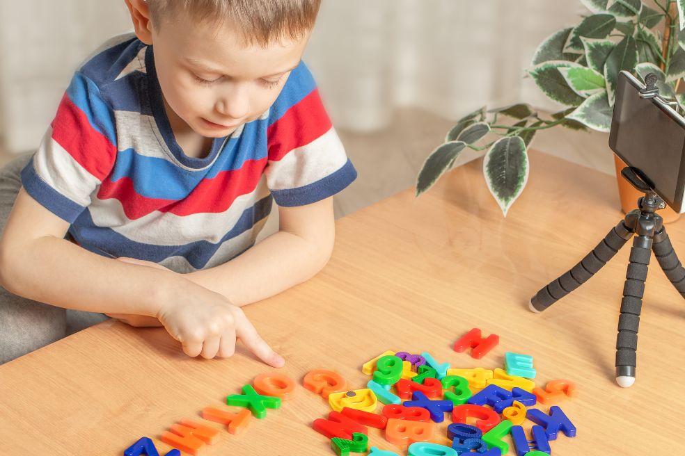 child playing word games with plastic letters