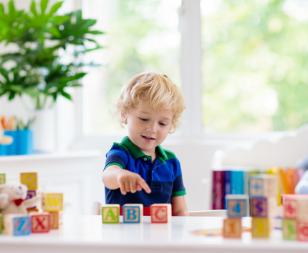 young boy playing with ABC blocks learning letter recognition