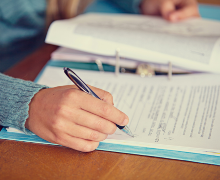 flatlay photo of someone writing in a document to record reading assessment results